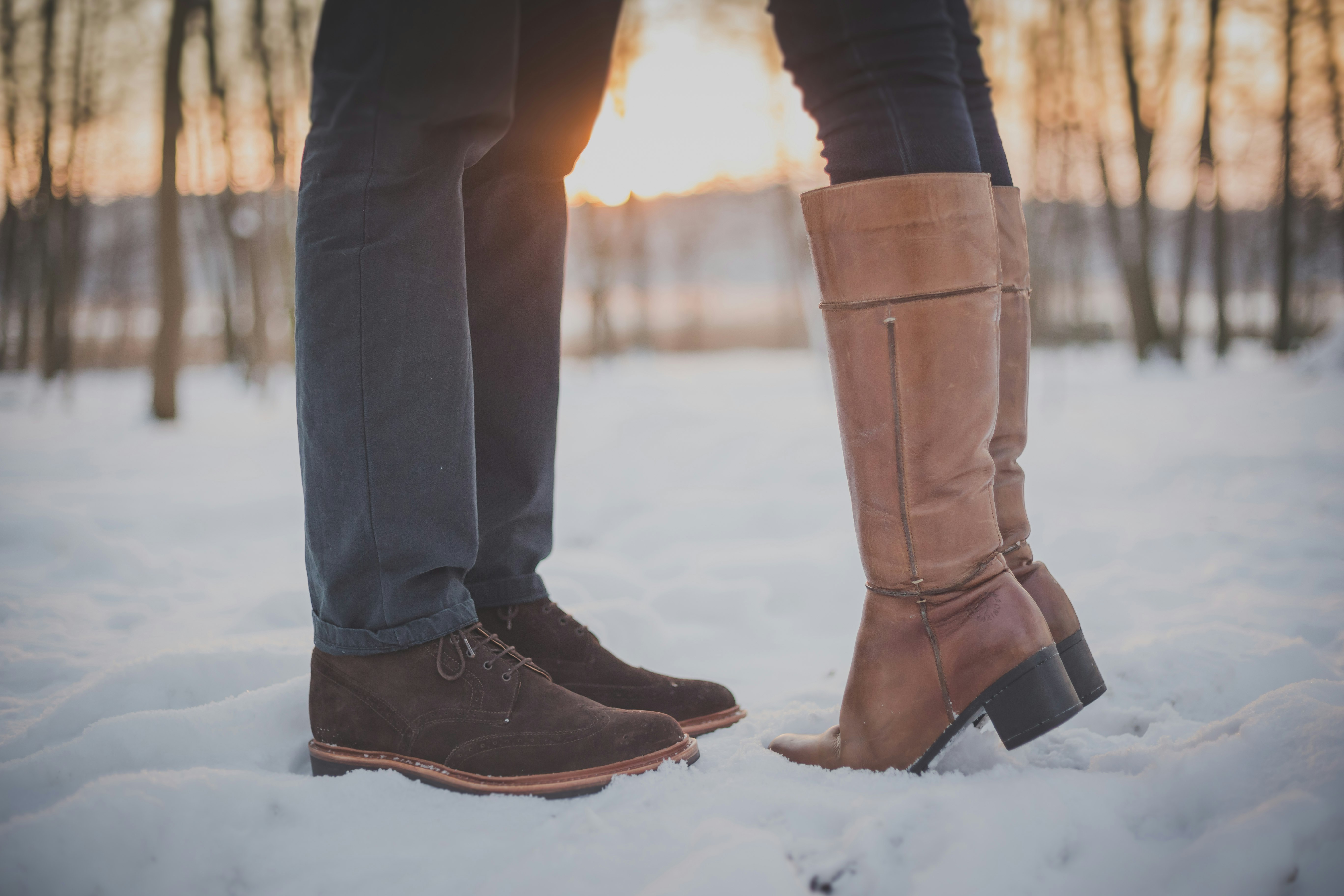 two person in brown boots and shoes on snowy forest